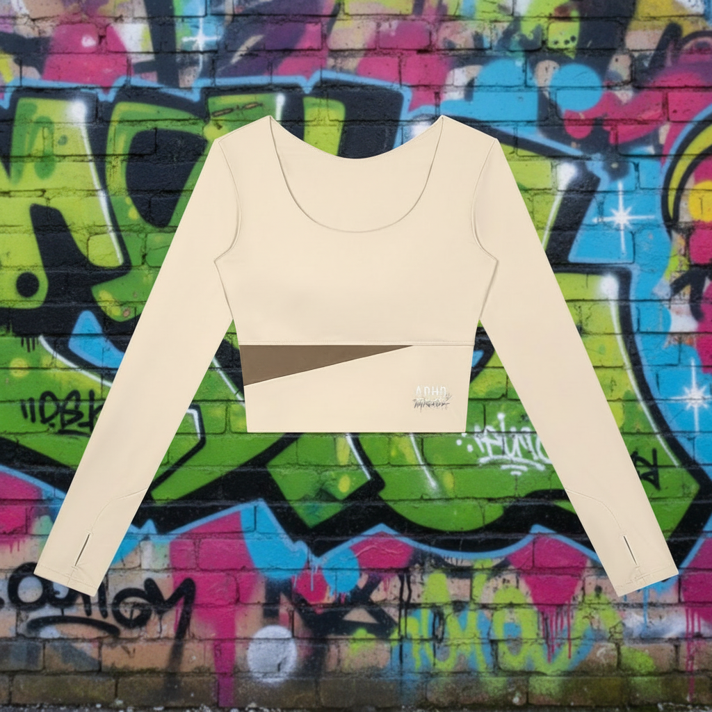 A beige long-sleeve crop top with a scoop neck, featuring a diagonal brown stripe across the chest and small red and gold printed details on the front.